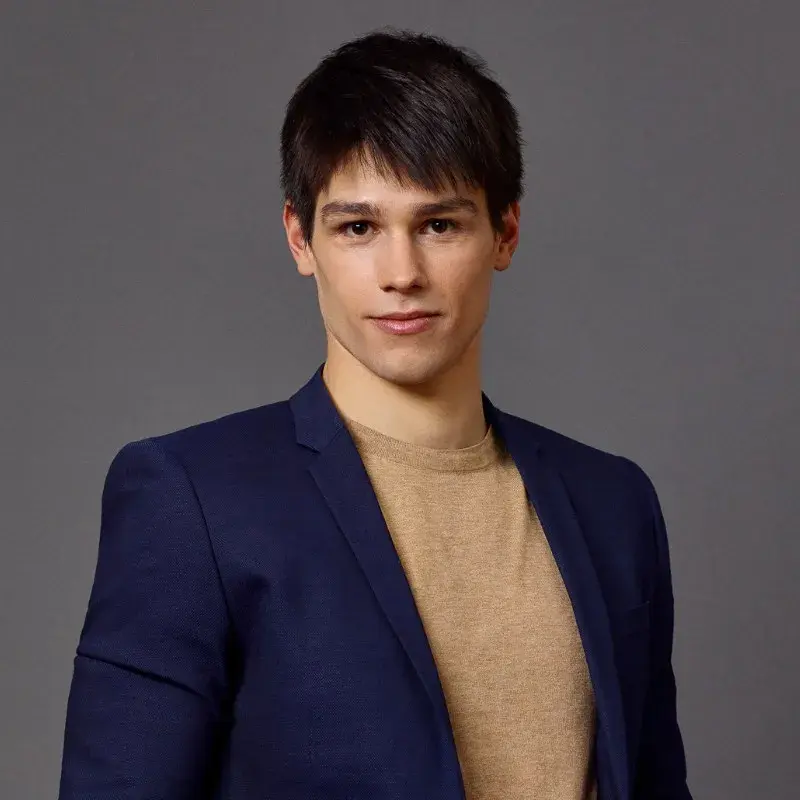 A young man in a suit jacket looking straight at the camera